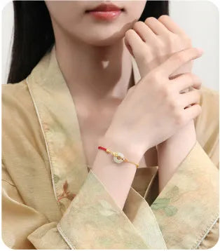 Women's 925 silver bracelet with gold electroplated peace buckle, koi fish charm, and adjustable red rope.