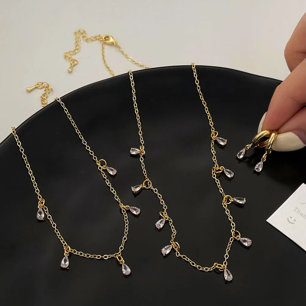 Women's zircon necklace, earrings, and anklet set with geometric pendant.