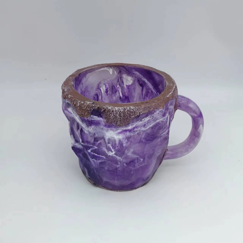 Purple and blue resin coffee mug with crystal texture and handle on wooden table