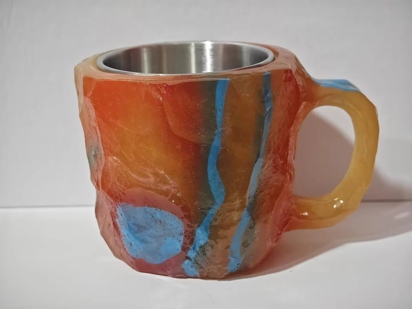 Purple and blue resin coffee mug with crystal texture and handle on wooden table