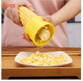 Yellow manual corn grinder thresher with corn-shaped PP handle on a kitchen counter.