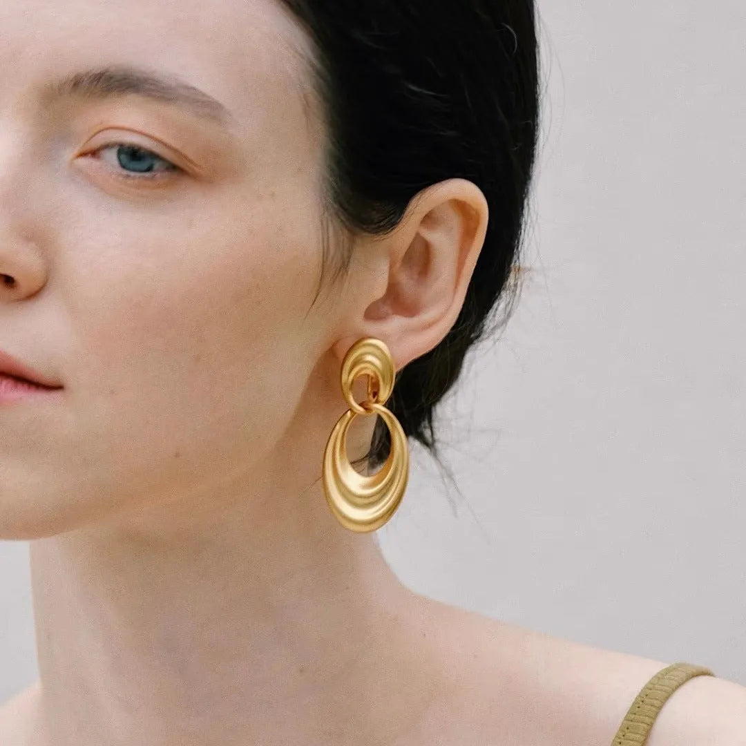 Gold coloured double circle French retro earrings with a U-shaped design and quicksand finish.
