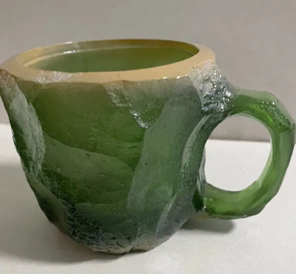 Purple and blue resin coffee mug with crystal texture and handle on wooden table