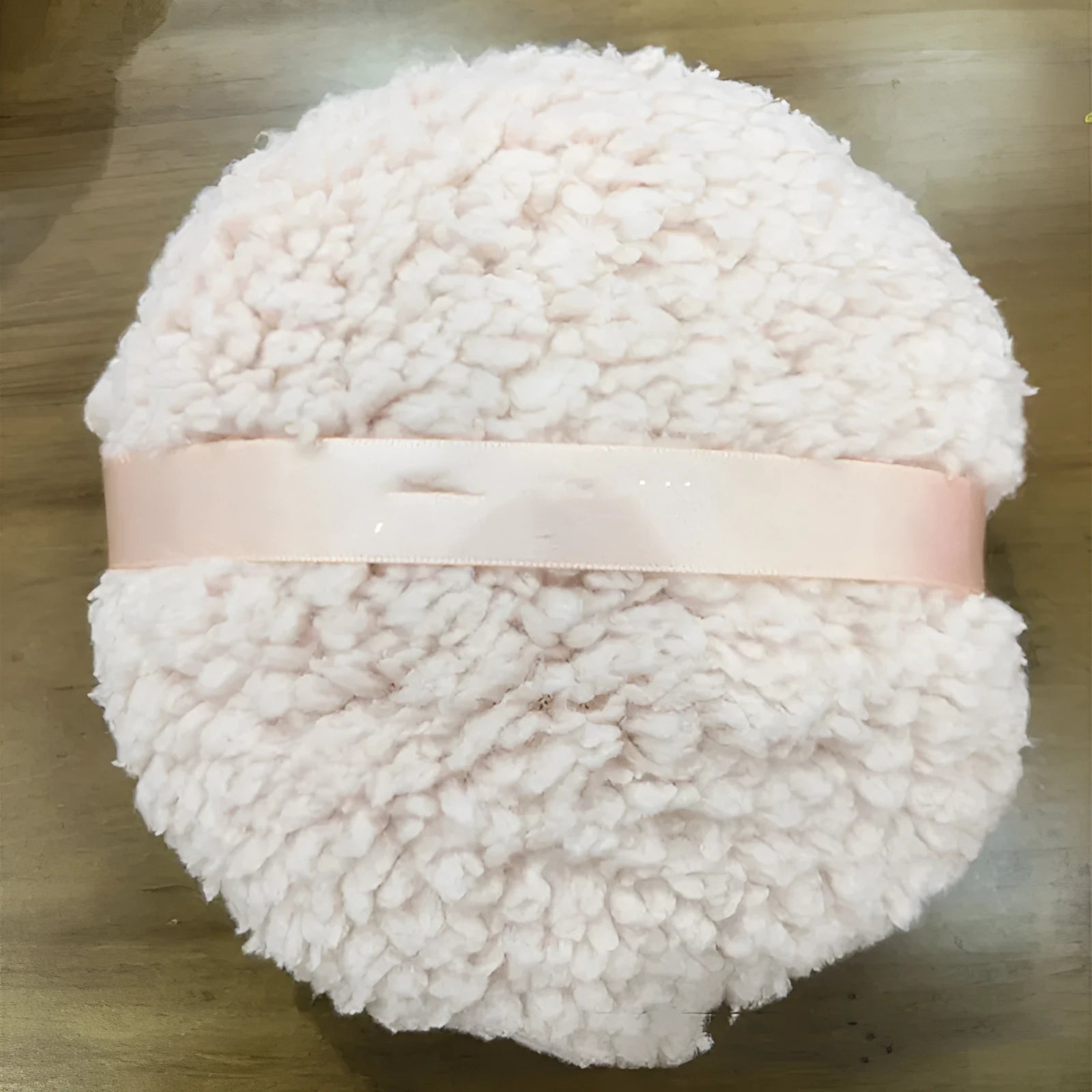 Oversized plush powder puff for makeup application in white colour with 150x75mm dimensions