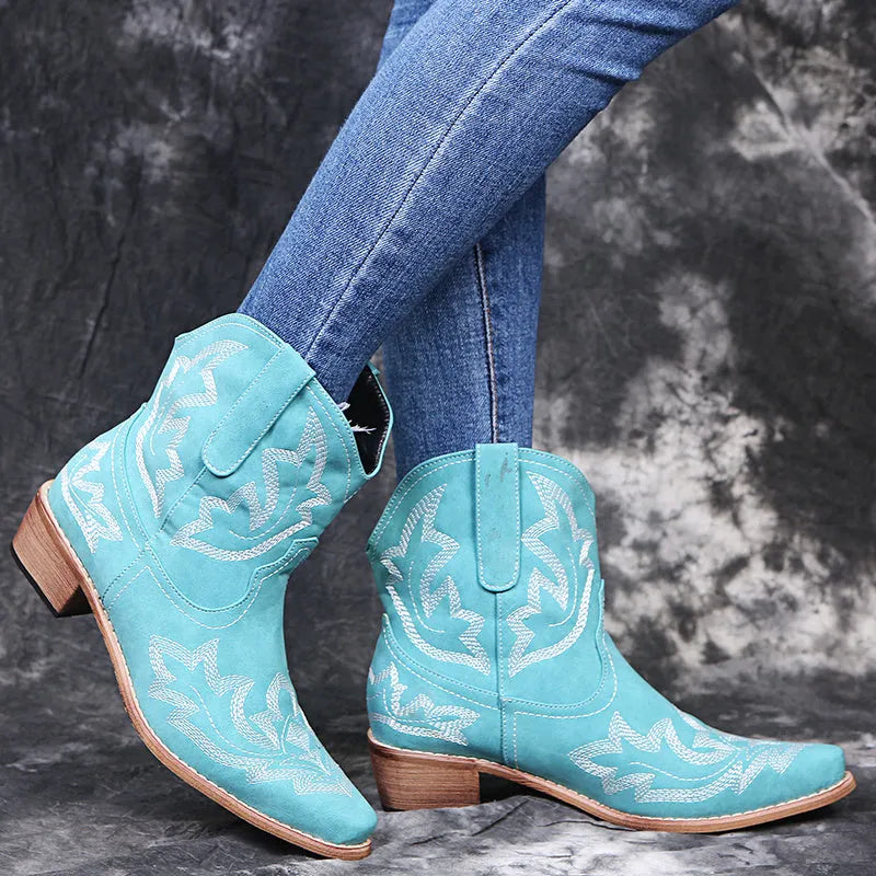Blue women's cowboy boots with embroidered detail, a low wedge heel, and a pointed toe.