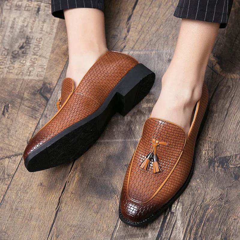 Men's black pointed toe slip-on business shoes with a tassel decoration on the front.