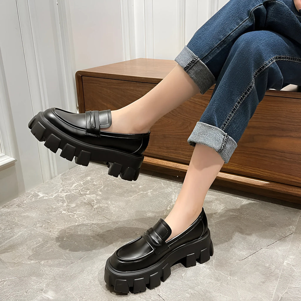 A pair of British style wide fit loafers with a muffin heel, shown in patent leather and matte colour options.