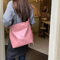 Corduroy single-shoulder commuter bag in pink with rectangular shape showing textured fabric