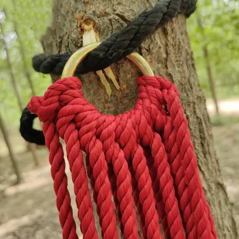 Outdoor nylon rope mesh hammock hanging between two trees showing mesh pattern and included tying ropes