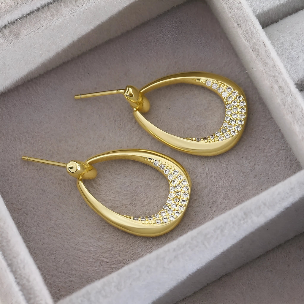 Yellow gold coloured geometric drop earrings for women, showing oval ring design.