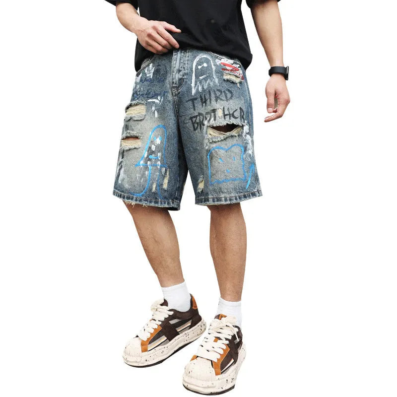 Blue men's denim shorts with ripped knees and graffiti图案, featuring a straight leg and zipper fly.