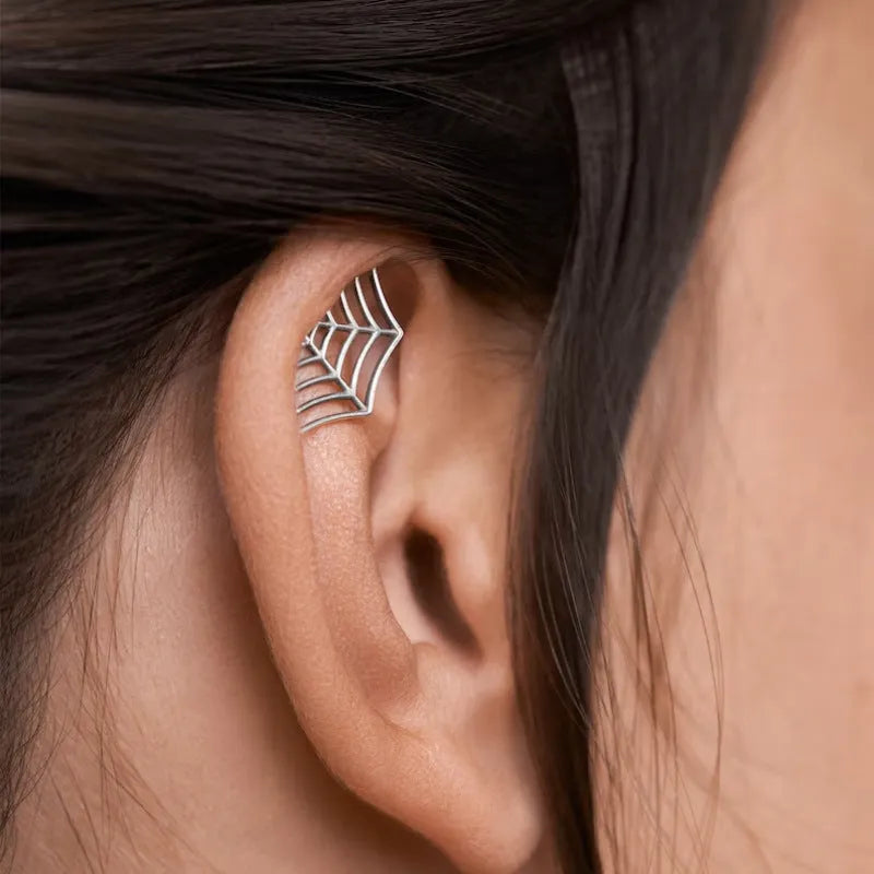 Spider web design stud earrings in gold and silver electroplated metal.