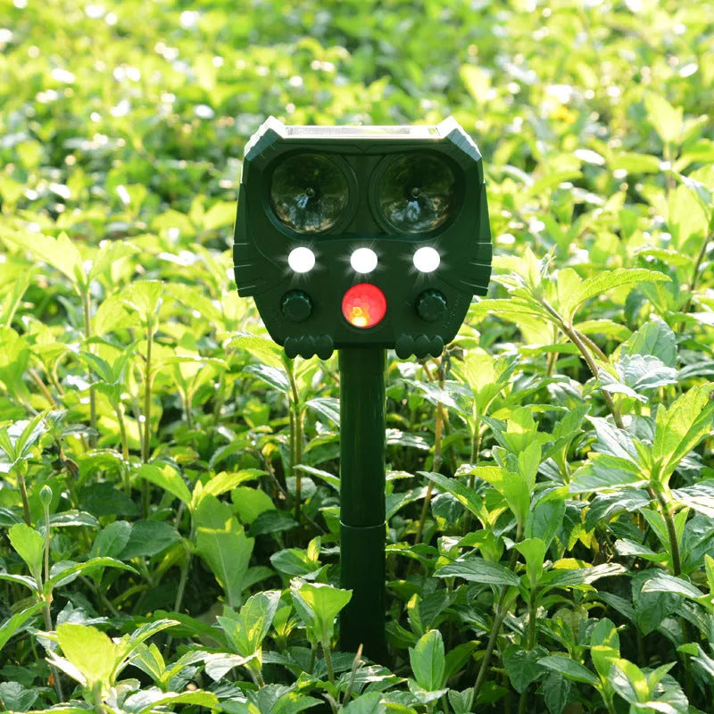 Green solar-powered ultrasonic dog and pest repeller unit for outdoor mounting