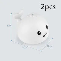 Electric whale bath toy with automatic water spray and flashing lights on a base