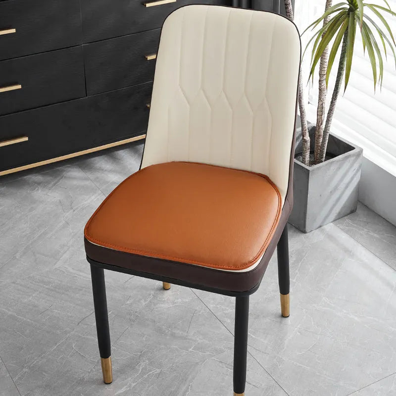 Leather horseshoe-shaped seat cushion on a dining chair, shown in a solid colour with a non-slip base.