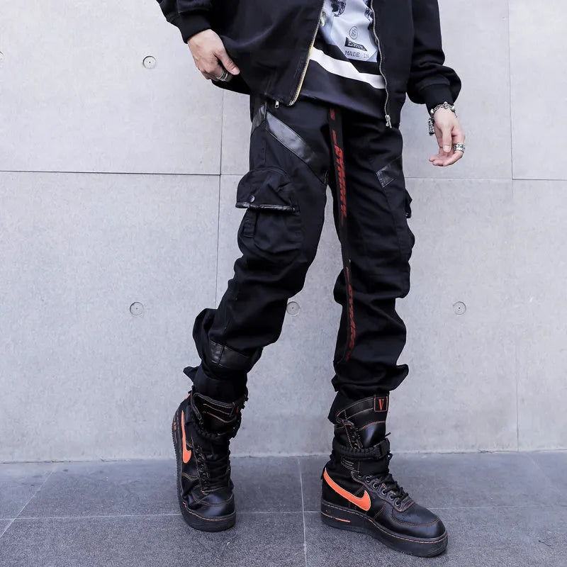 Black men's leather pocket splice cargo trousers with harem cut and long legs