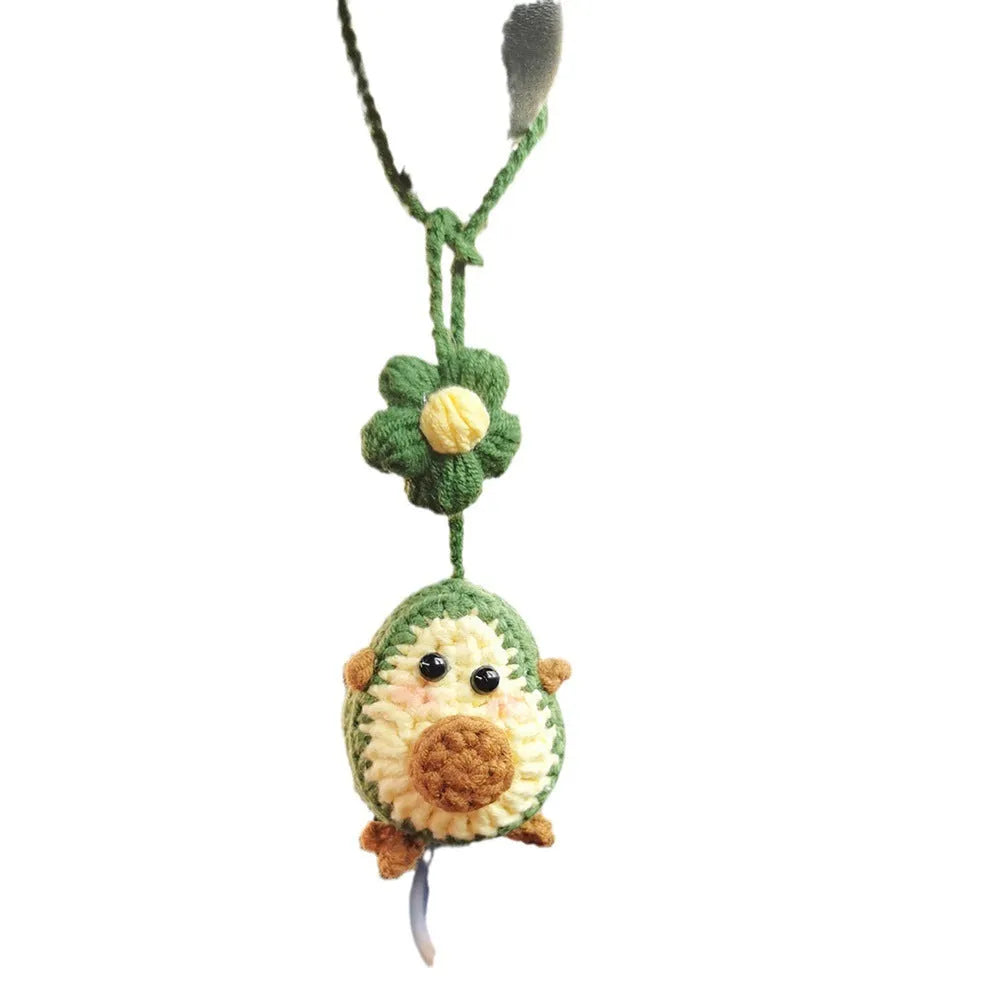 Handmade crocheted wool car pendant with a cartoon flower in avocado, pink rainbow, or red rainbow colours.