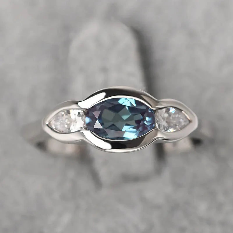 Geometric ellipse-shaped women's ring in white gold colour with inlaid zircon stones.