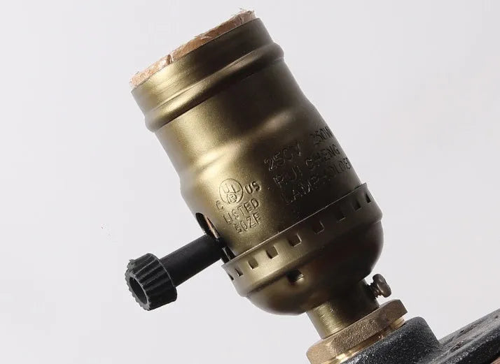 Wood and iron water pipe design table lamp measuring 9 cm wide by 13 cm high.
