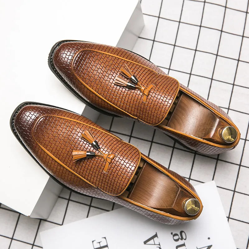 Men's black pointed toe slip-on business shoes with a tassel decoration on the front.