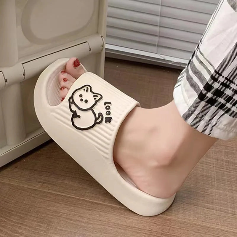 Green cat slippers with a thick EVA platform and non-slip sole on a wooden floor.
