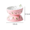 Orange ceramic raised cat bowl with tilted design and non-slip base on a table.