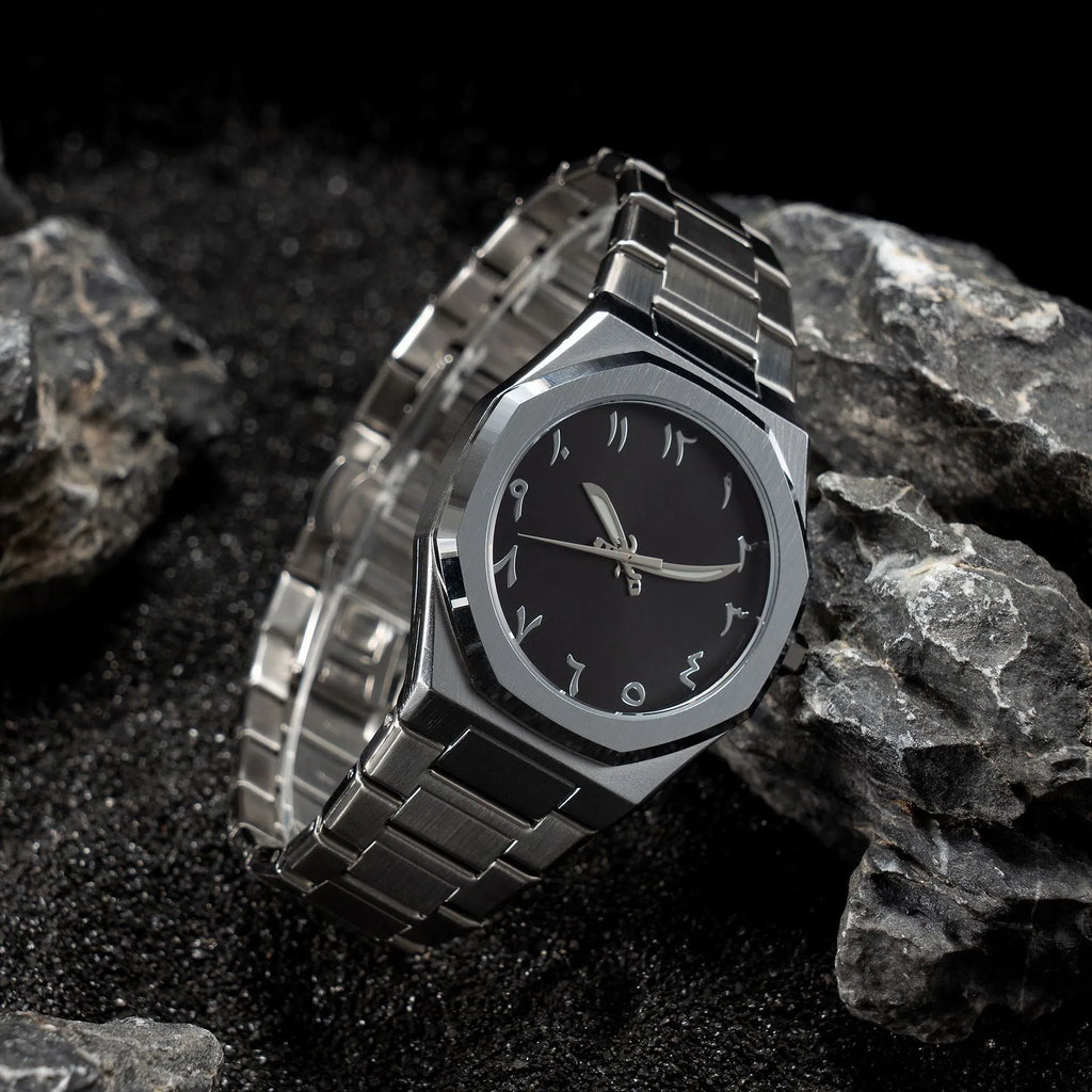 Men's business quartz watch with a steel bracelet and a black and silver dial on a wrist.
