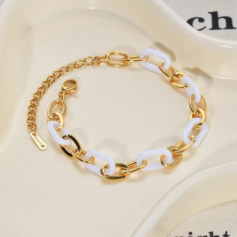 Women's stainless steel bracelet with double-layer design and a hanging heart charm in a resin-like electroplated finish.