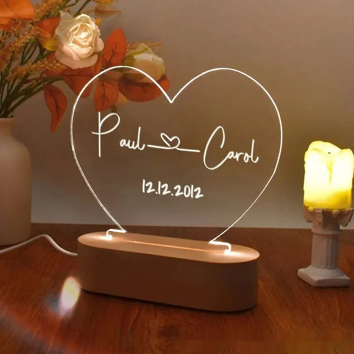 Custom engraved acrylic night light displaying personal names and a date, lit from a base LED.