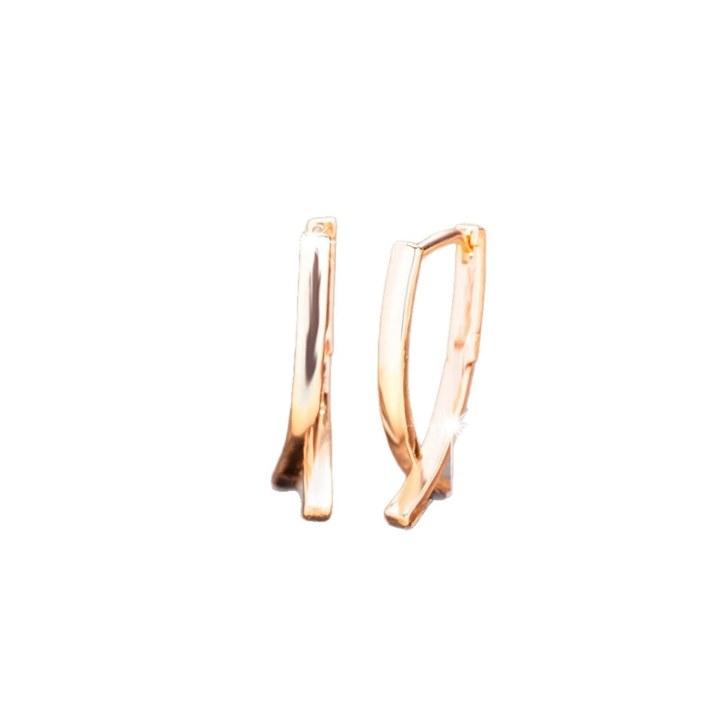 Single pair of rose gold cross shaped earrings made from copper with light luxury design