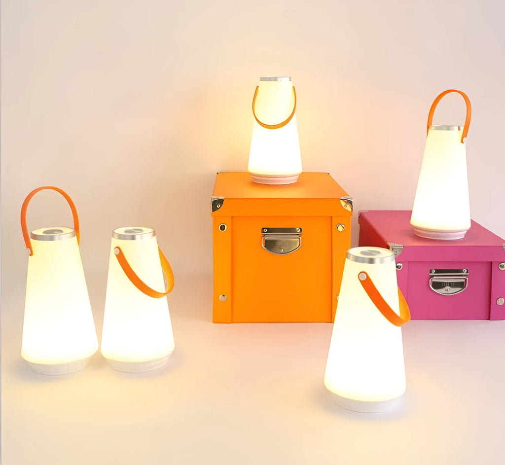 White rechargeable LED bedside table lamp with USB cable on a wooden surface.