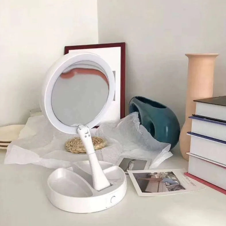 White foldable LED vanity mirror with USB charging port and double-sided storage compartment open on dressing table
