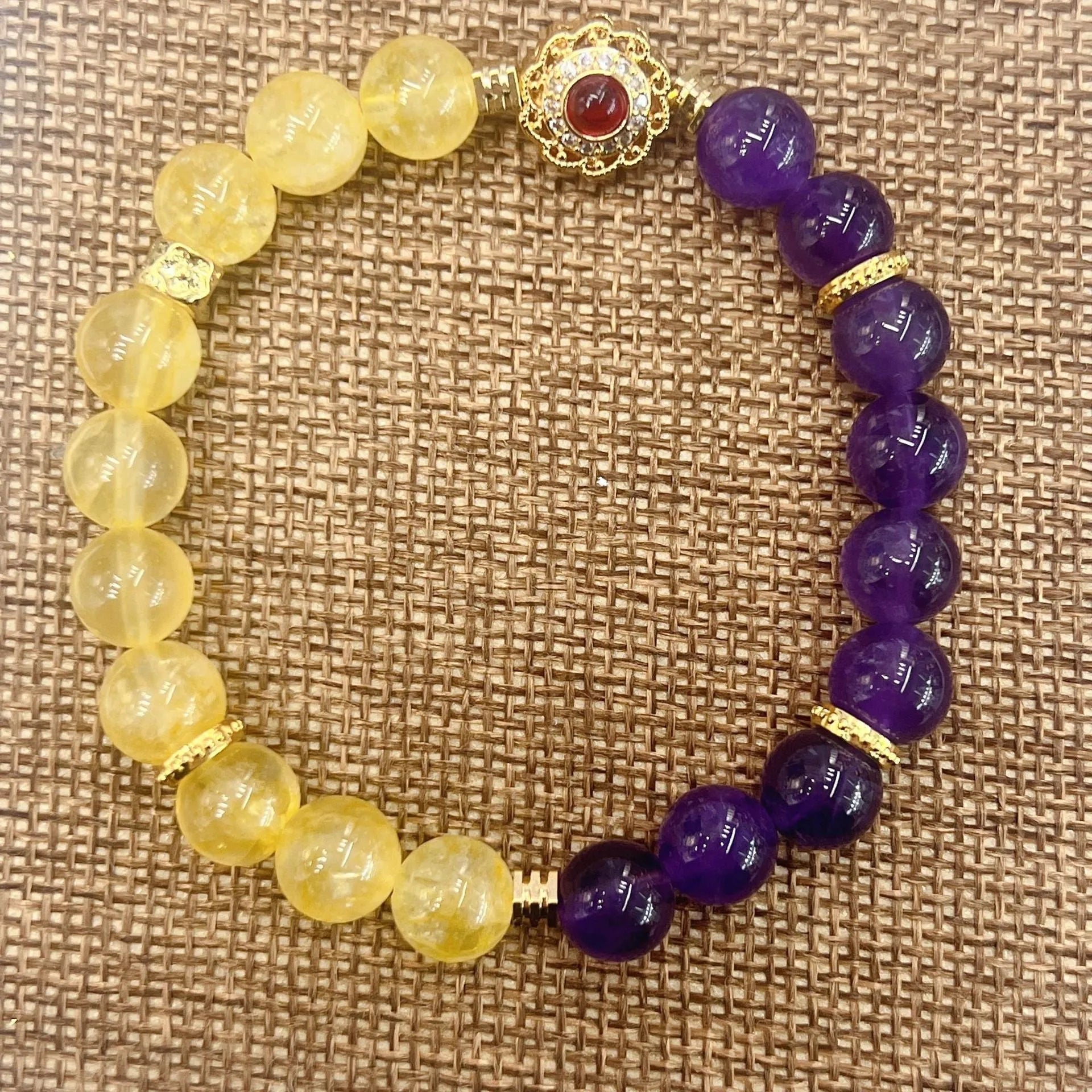 Handmade women's yellow and purple amethyst crystal bracelet showing manual craftsmanship details