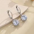 Silver colour zircon earrings with genuine stones and secure metal fastening on a white background
