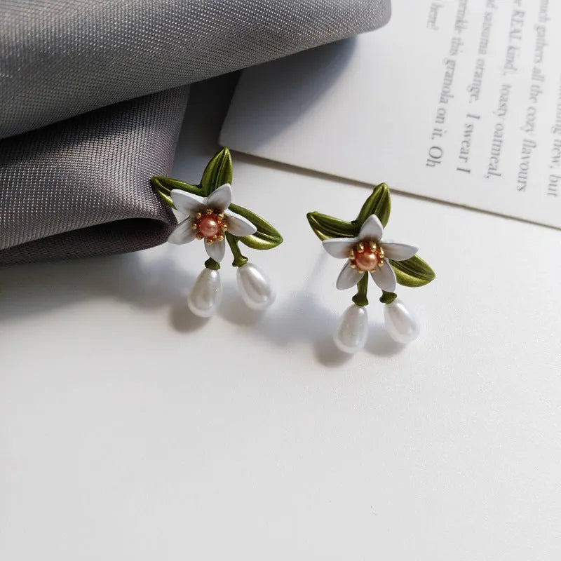 A pair of women's alloy flower-shaped clip-on earrings with contrasting sterling silver needle floral details.