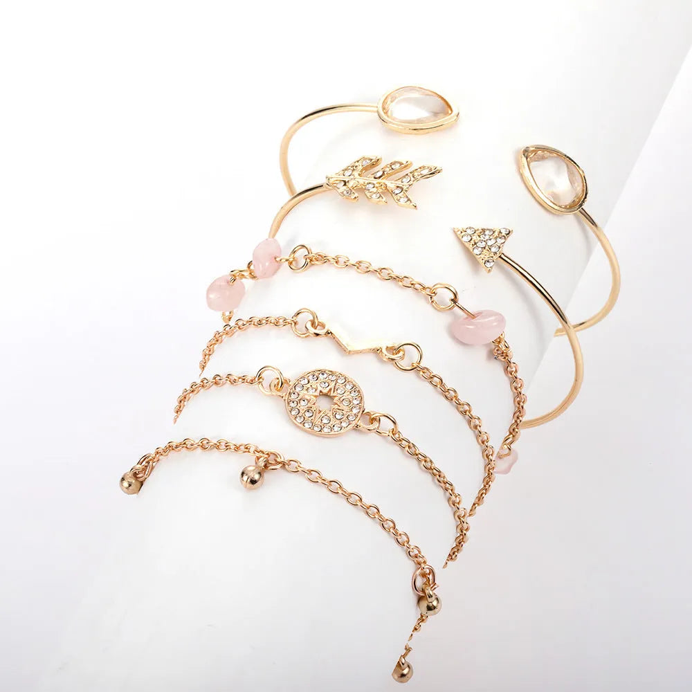 Gold-coloured zinc alloy bracelet set with six charms including arrow, water drop, V, and spot drill designs.
