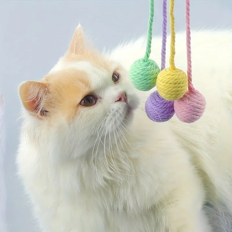 Green and pink plastic cat toy balls with ropes and internal bells.