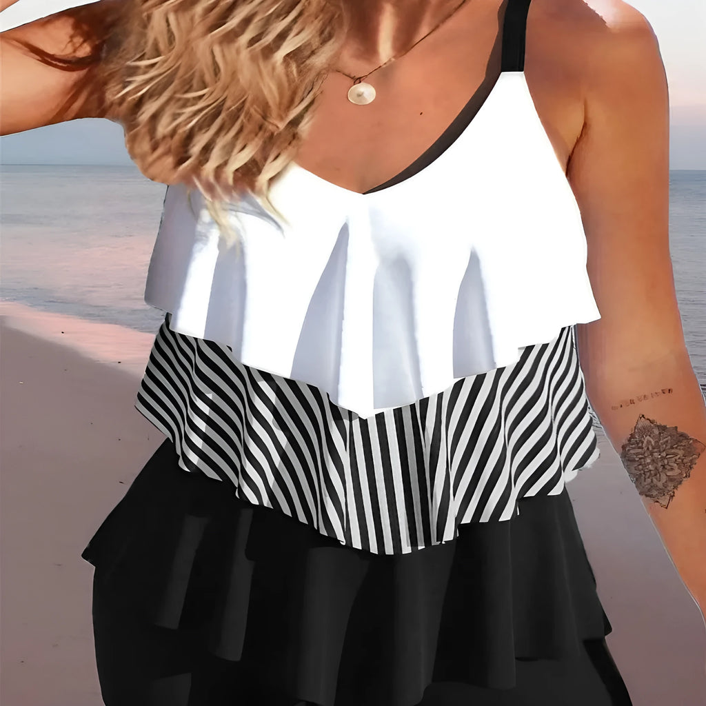 Women's sleeveless backless bikini with spaghetti straps and ruffle trim, shown in a solid colour.
