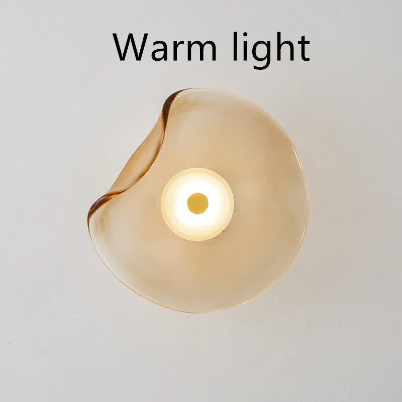 Round decorative wall lamp with glass shade in choice of cognac, light purple, or smoky grey finishes for bedroom lighting