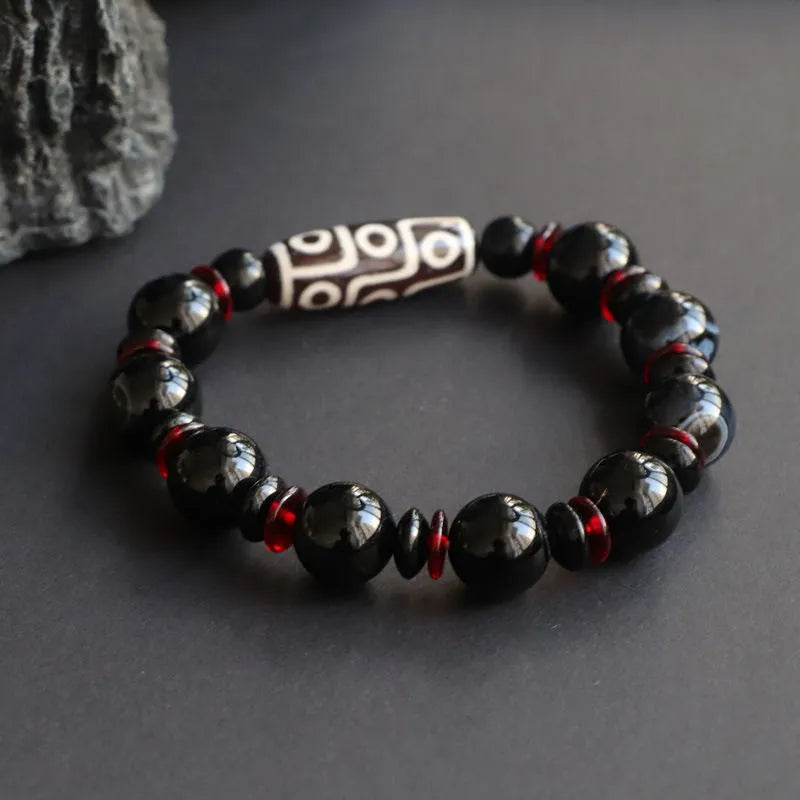 Black agate dzi bead bracelet with geometric beads and hand-woven construction