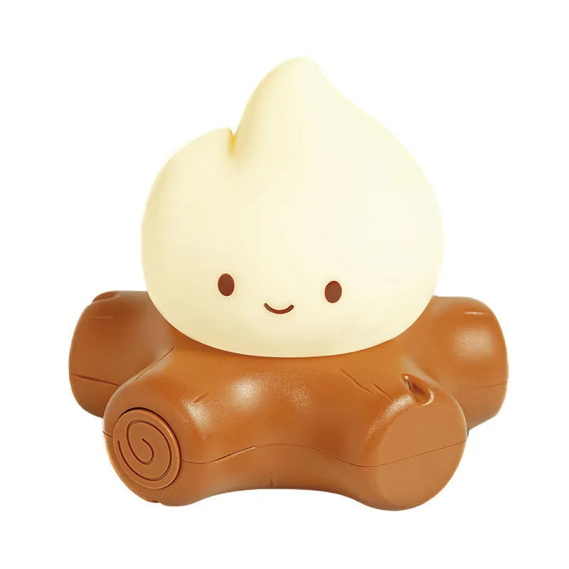 Small cartoon silicone fire pile night light with yellow LED glow and ABS shade on wooden surface.
