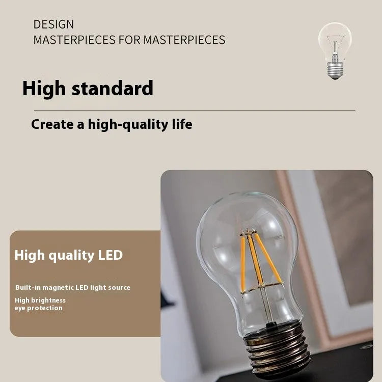 Creative iron art suspension bulb night lamp on a black wood grain desktop base.