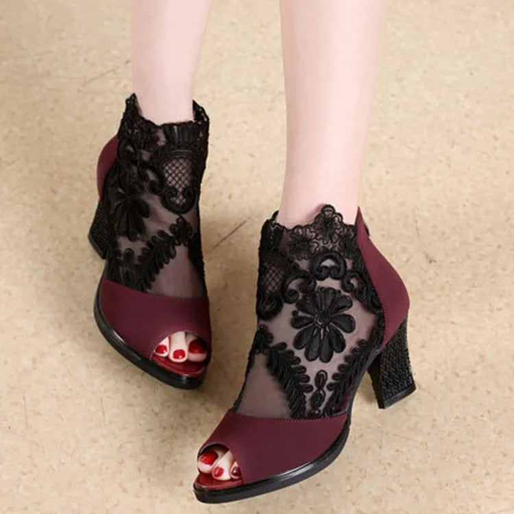 Women's black lace-up gladiator sandals with a square high heel and decorative floral detail on the peep toe