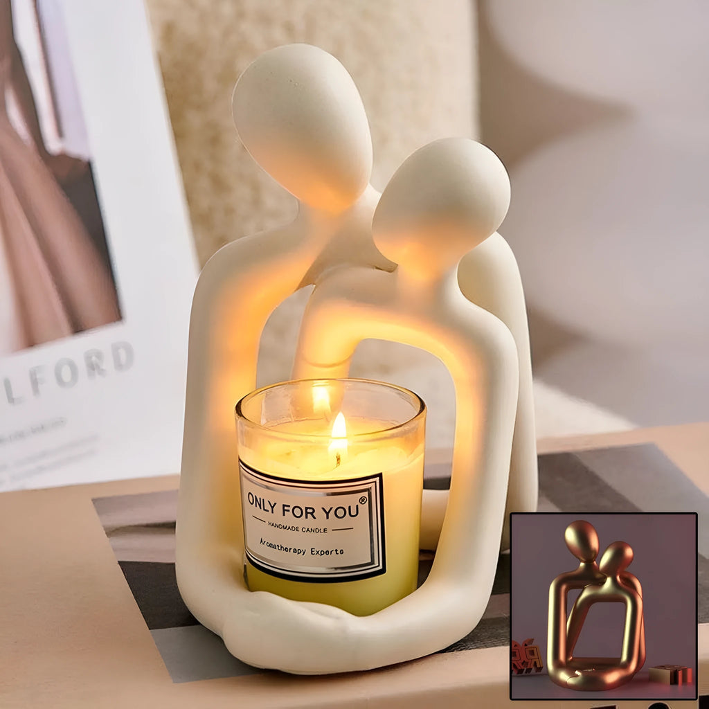 Modern loving couple resin statue in milky white or gold on a bookshelf.