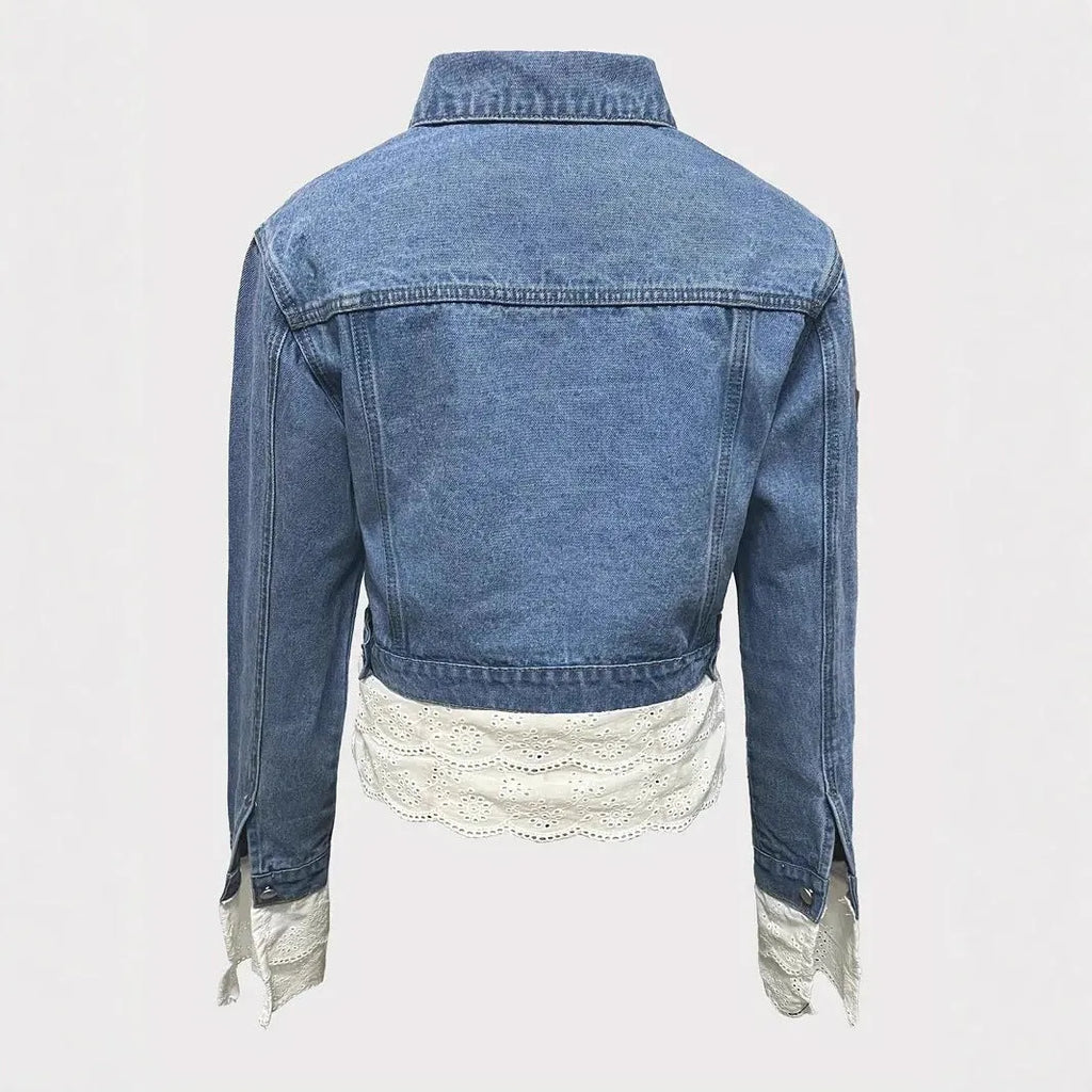 Blue women's denim jacket with lace stitching detail on the front, with long sleeves.
