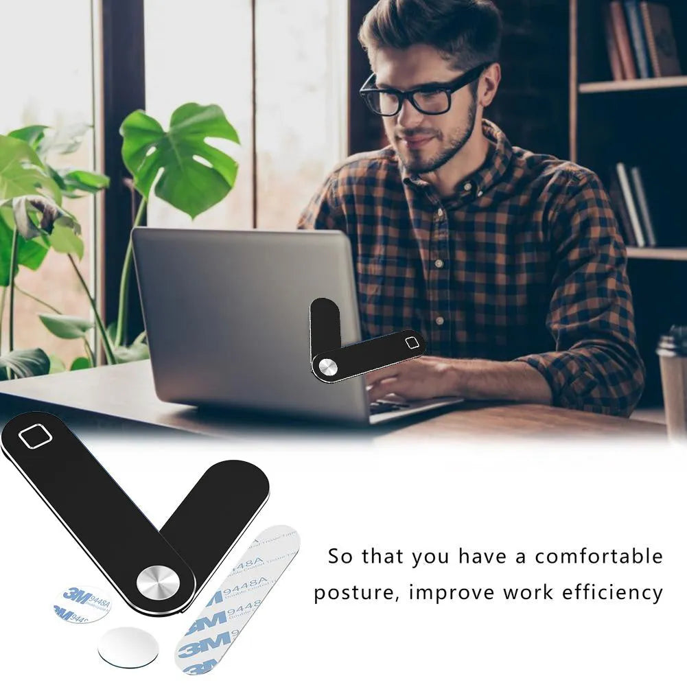 Black aluminium laptop phone holder with magnetic clip attached to a laptop screen, holding a smartphone.