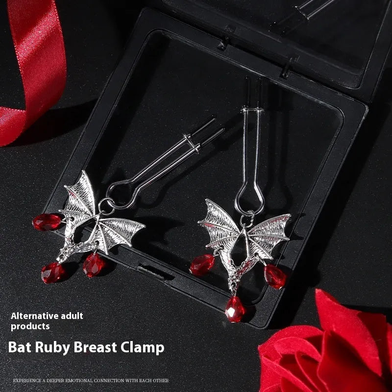 Silver bat-shaped nipple clamp with ruby detail and adjustable tension mechanism