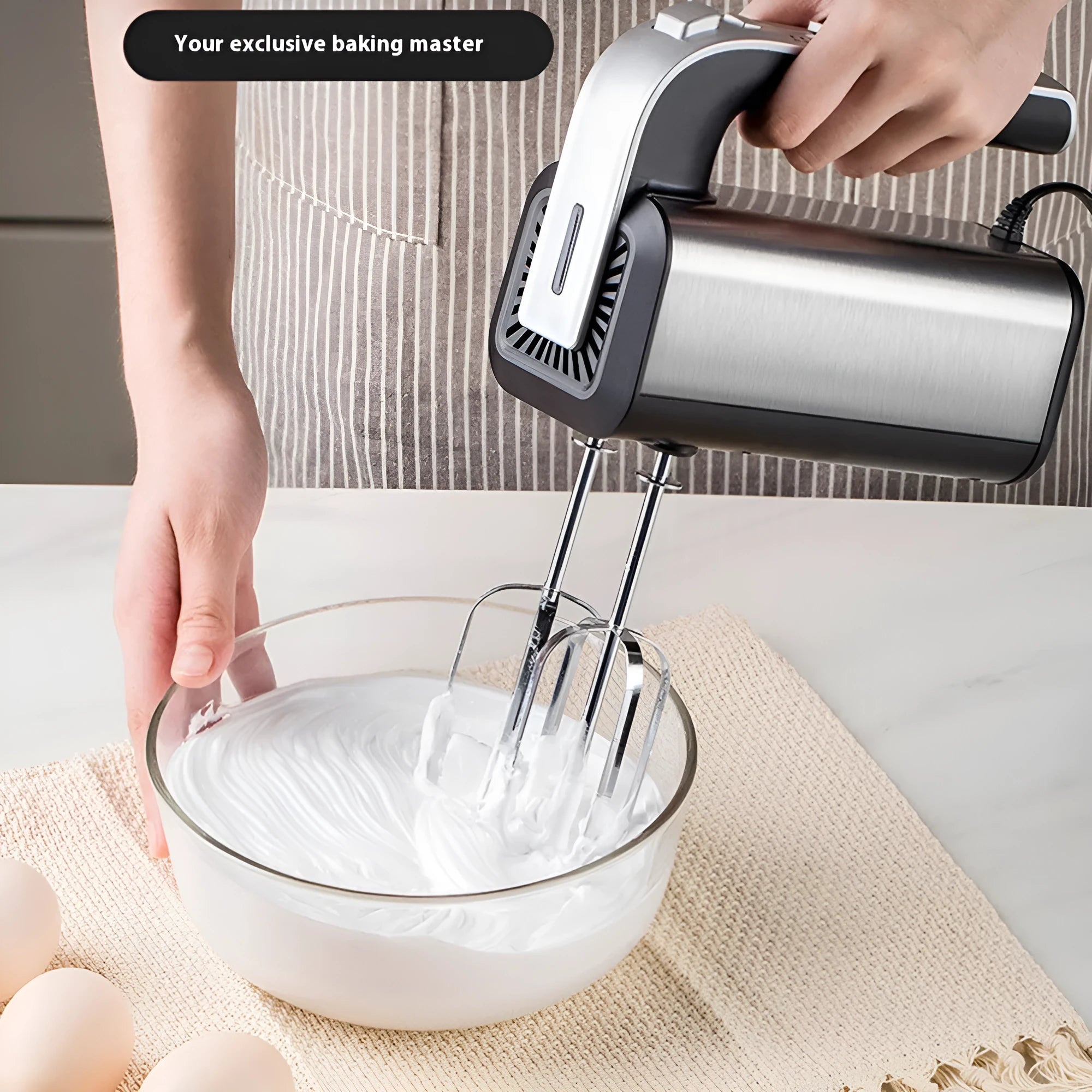 Silver mini electric hand mixer with stainless steel beaters on a 5-speed control dial.