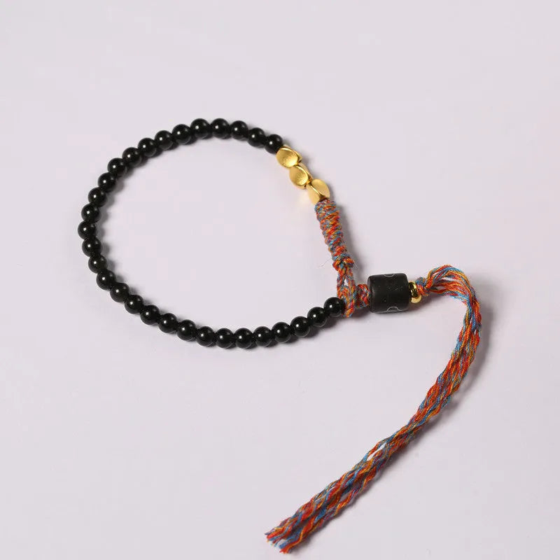 Hand-woven obsidian bracelet with dark beads showing woven texture and adjustable 15.5-16cm length