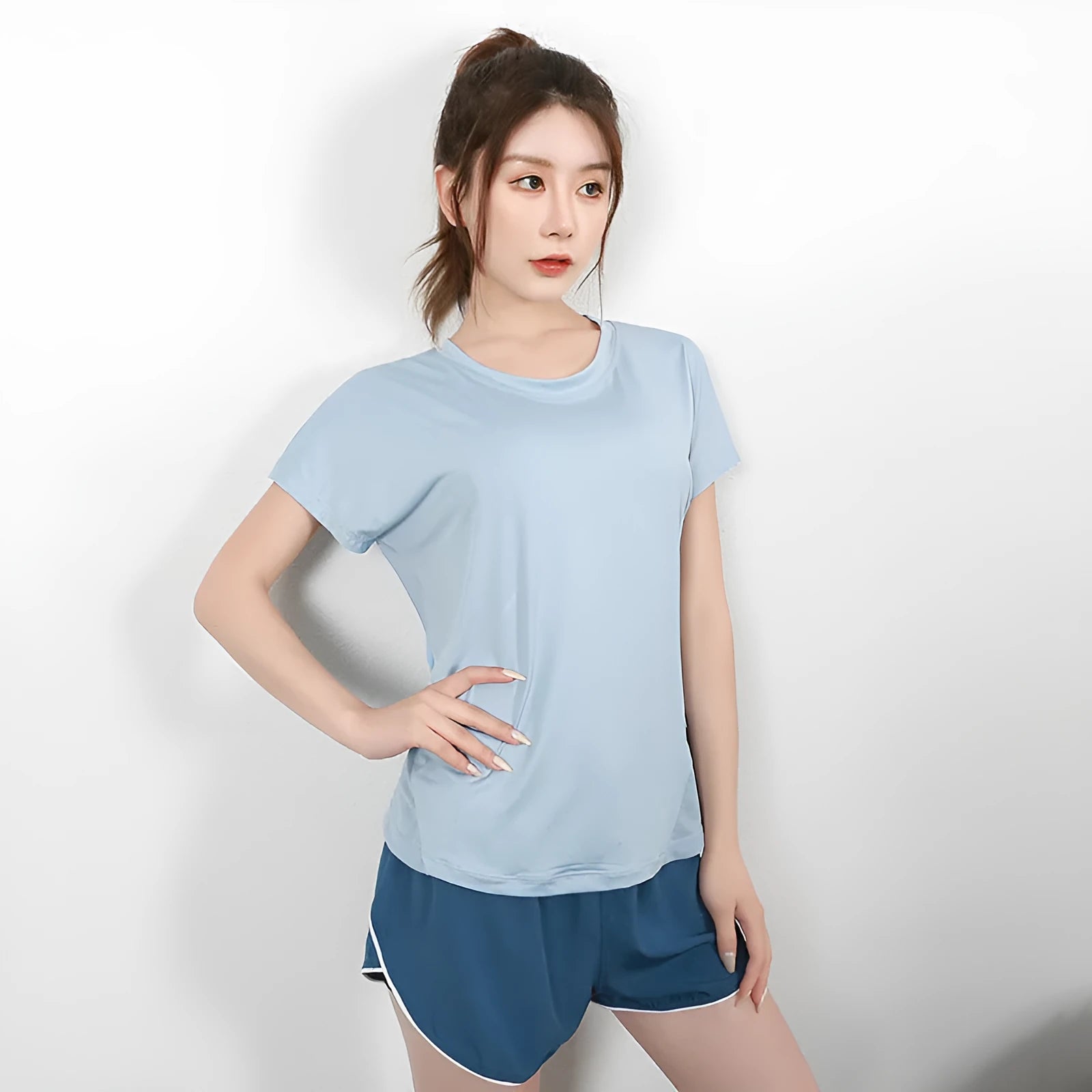 Women's short sleeve polyester sports t-shirt for yoga and running in pink, on a hanger.